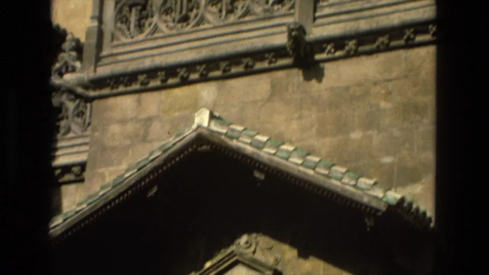 Descending 1978 Córdoba exterior view showing a small tiled gable below ornate carved stonework.