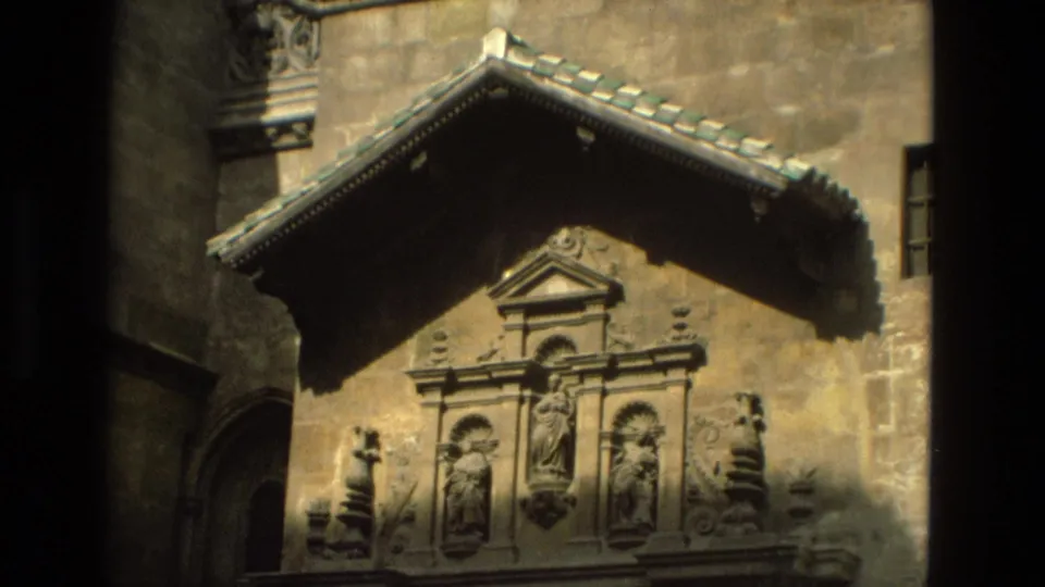 1978 Córdoba 8mm frame showing sculpted niches and a tiled gable on an ornate historic stone exterior.
