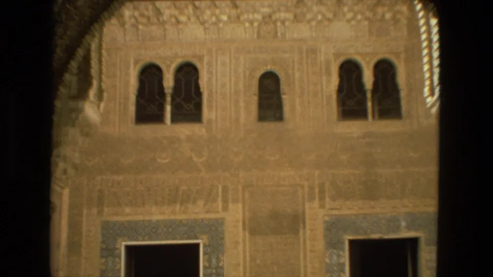 Closer 1978 Córdoba view of ornate wall carving, arched windows, and blue tile panels within a historic courtyard.