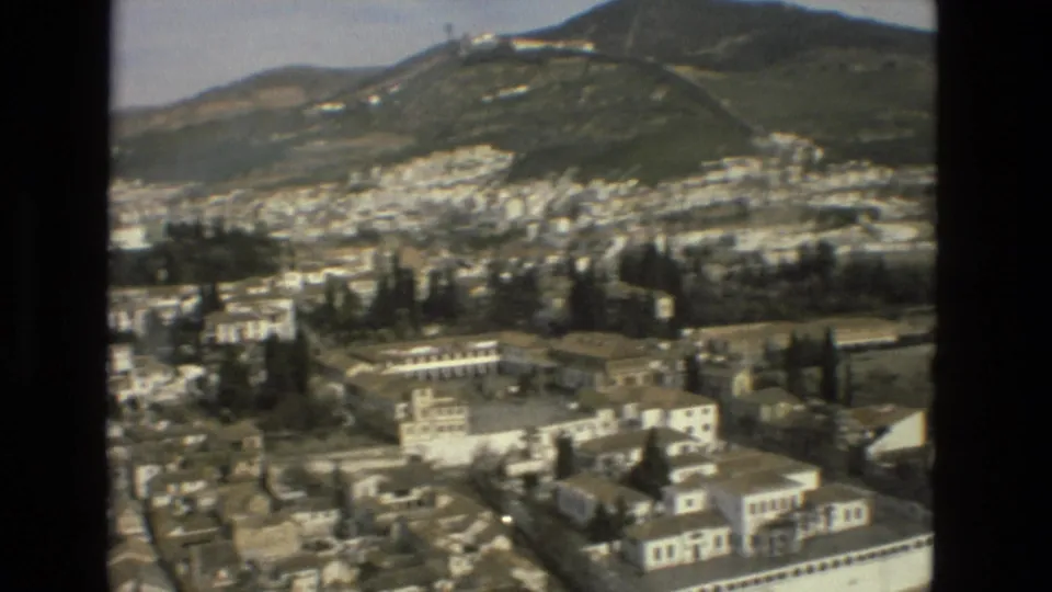 Elevated 1978 Córdoba view with white city blocks, roads, trees, green hillside, and a hilltop structure in the distance.