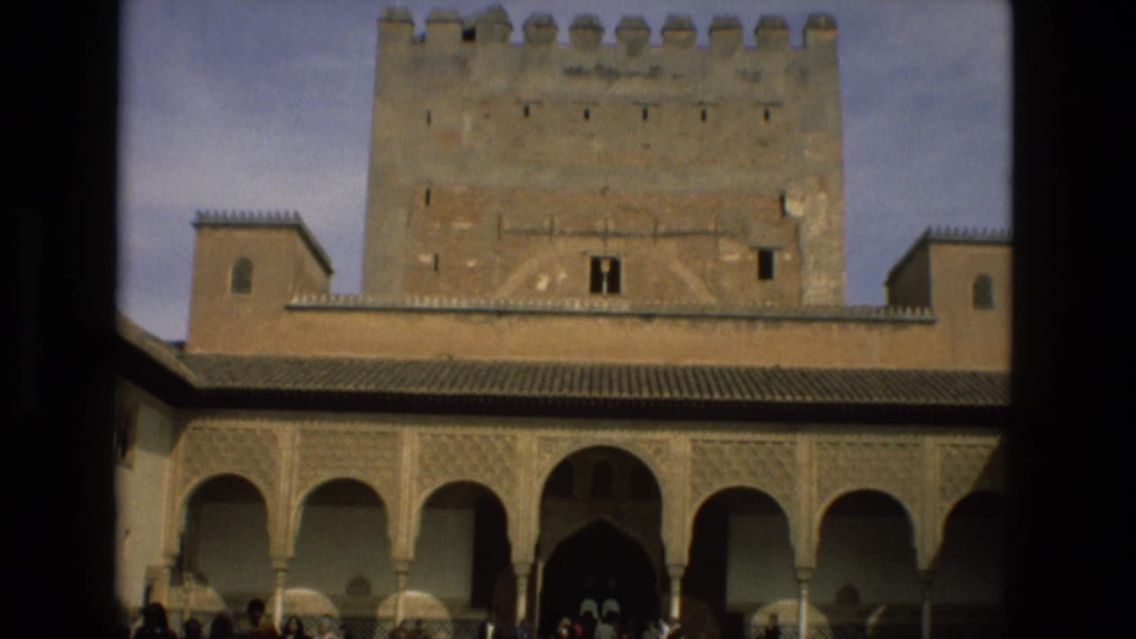 1978 8mm view of the Alcázar of Córdoba courtyard, with a stone tower above Moorish-style arches.