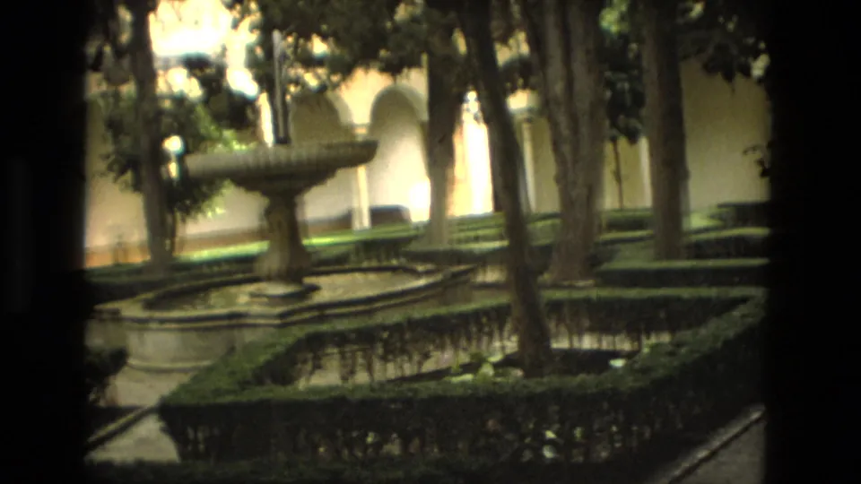 1978 Córdoba home-movie view of a courtyard fountain, reflecting pool, hedges, trees, and arched walkways.