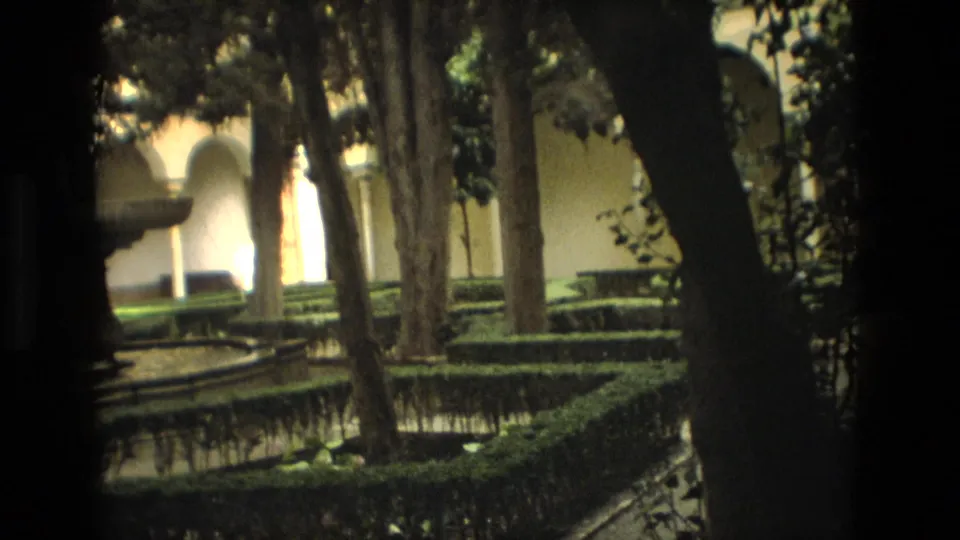 1978 Córdoba frame showing shaded trees, clipped hedges, reflecting water, and pale arches in a courtyard garden.