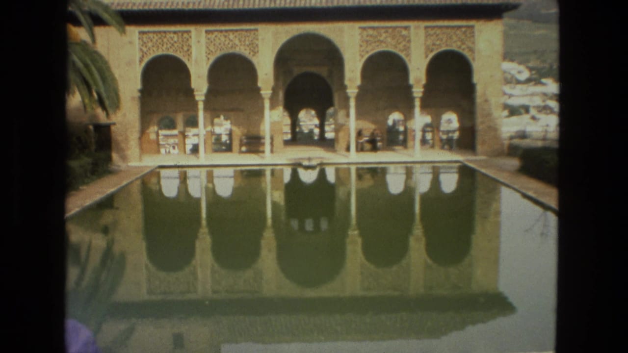 Reflection pool and arched facade with a few distant visitors.