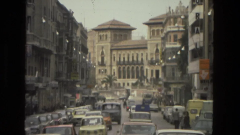 1978 Córdoba street scene with classic cars, pedestrians, balconies, signs, and a prominent arched-window building at the end of the view.