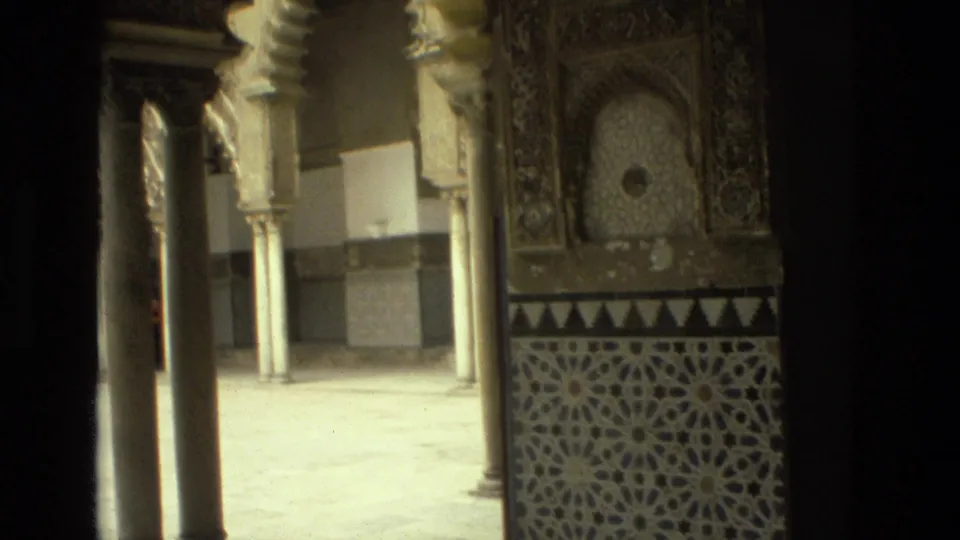 Final 1978 Seville frame showing the ornate interior from a slightly wider angle, including columns, carved panels, wall niches, and geometric tiles.