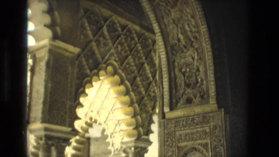 1978 Seville home-movie view of a scalloped arch, slender columns, carved upper border, and warm light on ornate stone surfaces.