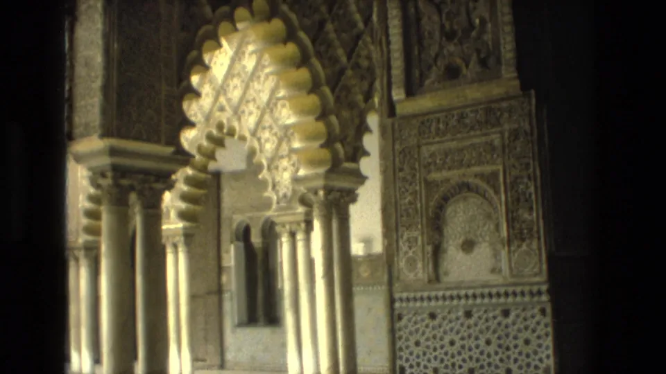 1978 Seville frame showing a Moorish-style courtyard detail with scalloped arch, columns, carved surround, and patterned lower wall panel.