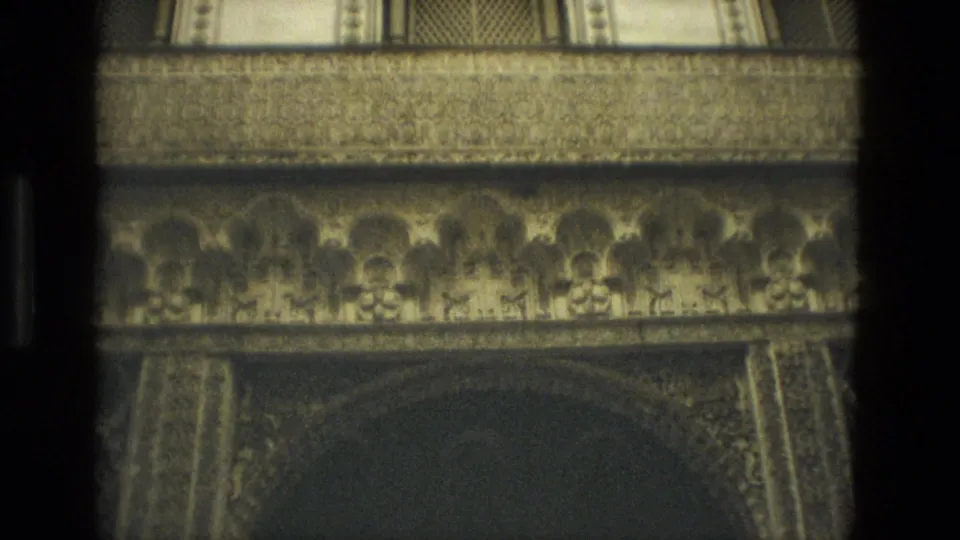 1978 Seville 8mm frame showing ornate interior arches, carved friezes, and patterned stonework in dim light.
