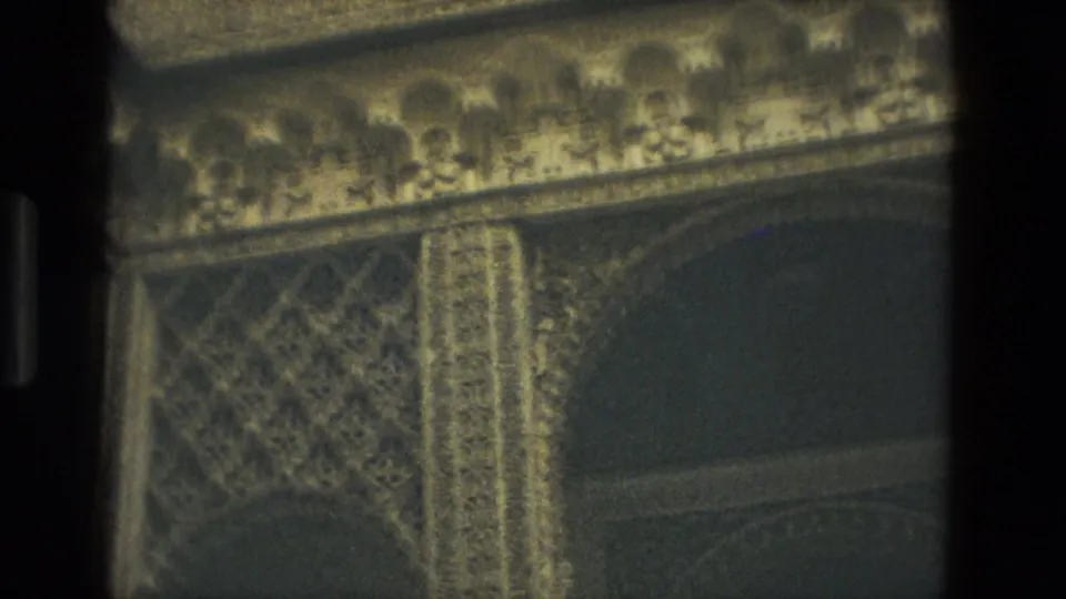1978 Seville 8mm frame with a close view of carved arch details, geometric patterning, and a dark recessed opening.