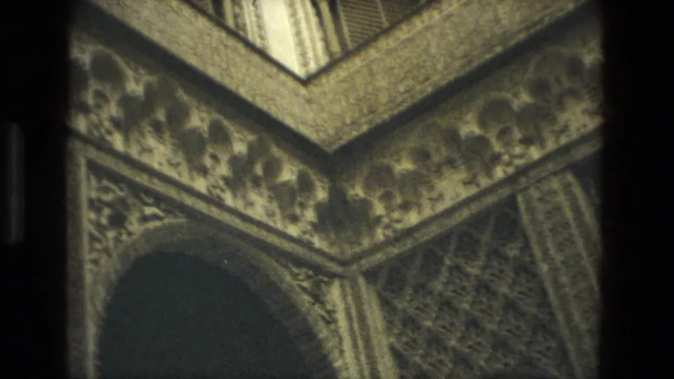 1978 Seville 8mm frame showing an angled visitor view of decorative arches, carved bands, and patterned interior stonework.