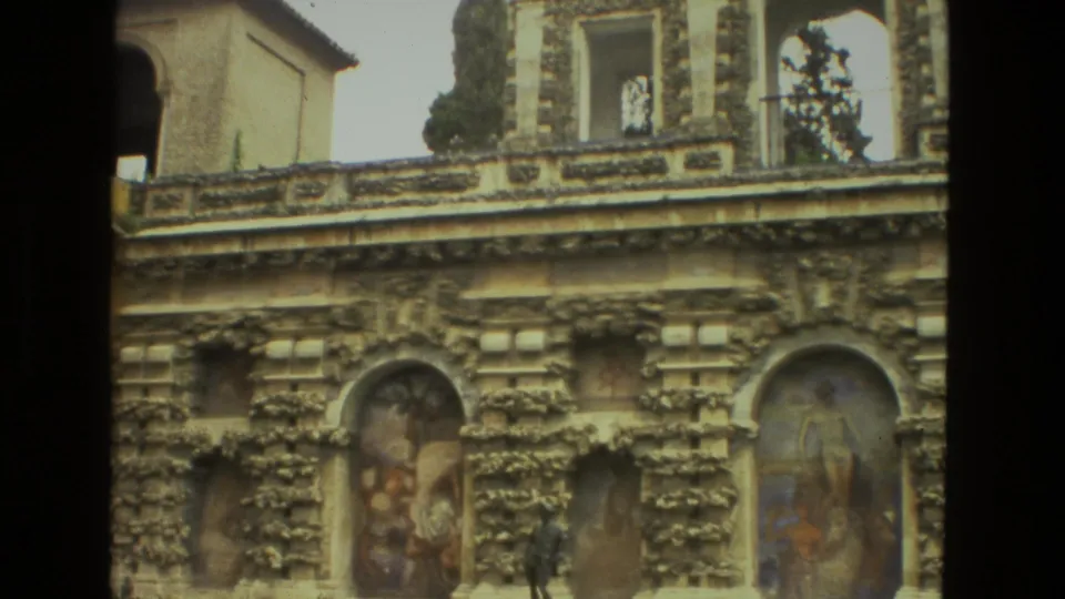 1978 Seville 8mm frame showing a decorative historic facade with frescoed niches, carved stonework, and partial upper arcade openings.
