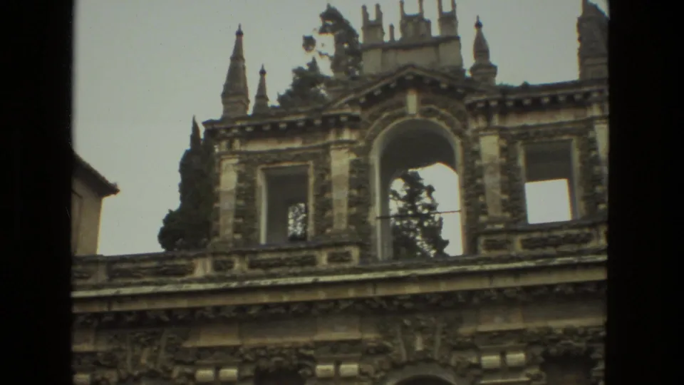 1978 Seville 8mm frame centered on the upper arcade and decorative roofline of an ornate historic building facade.