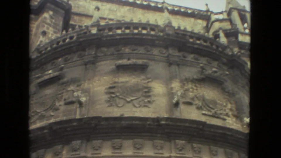 Close 1978 8mm view of Seville Cathedral stonework, showing rounded architectural detail, carved reliefs, and upper facade elements.
