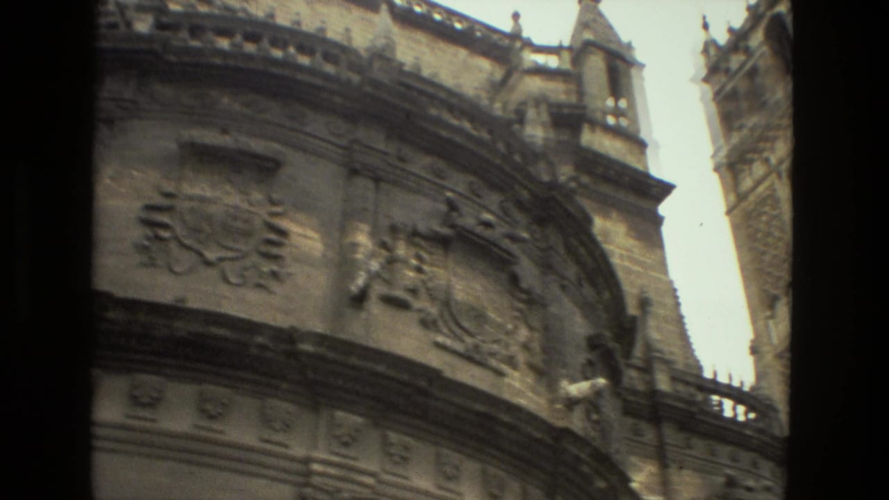 Ornate curved stone facade with carved reliefs and tower details.