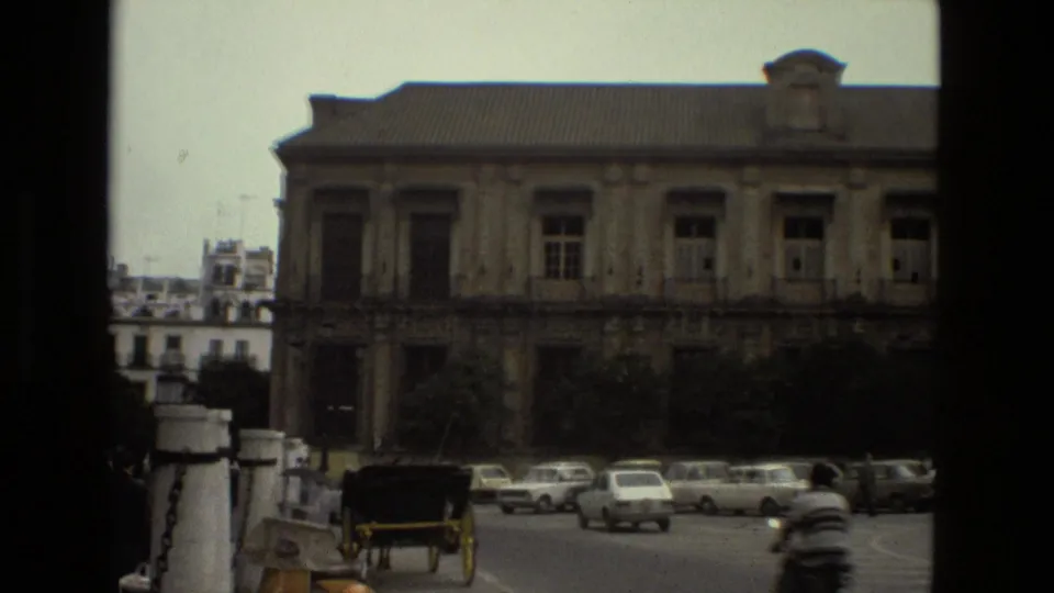 1978 Seville street view with a classical building, parked cars, and a horse-drawn carriage in the foreground.