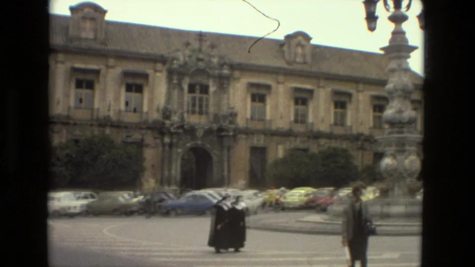 Nuns walk across a Seville crosswalk in 1978 while pedestrians, cars, and historic architecture fill the square.