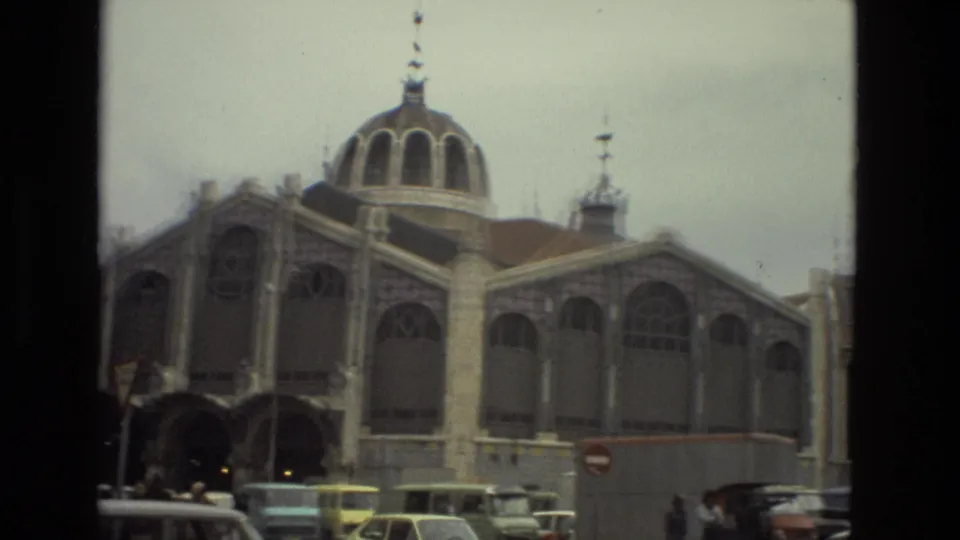 1978 Barcelona 8mm frame showing a large domed building with arched windows and period cars along the street.