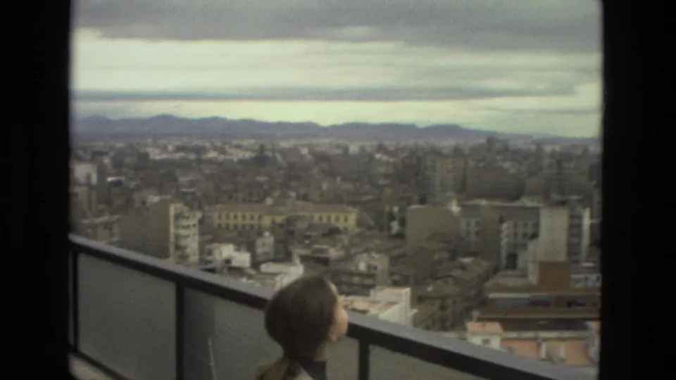 A 1978 Barcelona balcony view shows the young woman near the lower edge of frame as the city stretches toward distant hills.