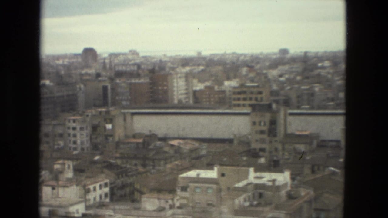 Elevated view across dense city buildings seen through dark vertical frame edges.