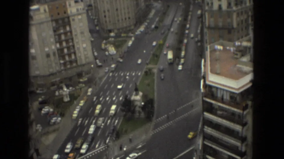 Elevated 1978 Barcelona street view looking down on wide roads, traffic lanes, cars, buses, and surrounding apartment buildings.