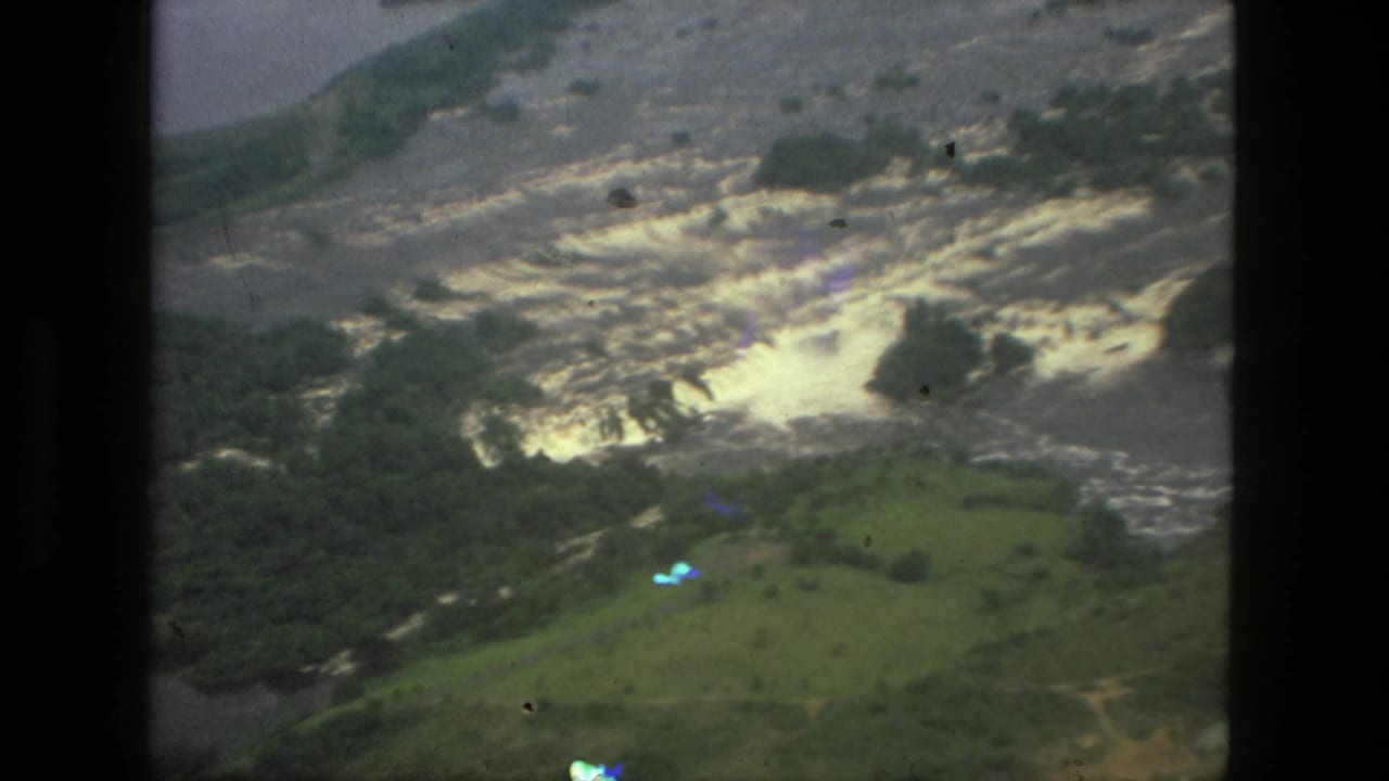 1979 Manaus aerial 8mm frame showing flooded green terrain and turbulent pale water from an airplane-window viewpoint.