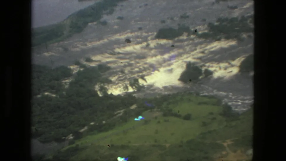 1979 Manaus aerial 8mm frame showing flooded green terrain and turbulent pale water from an airplane-window viewpoint.