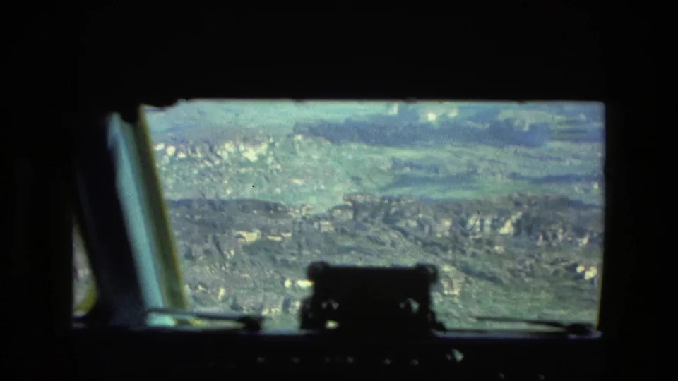1979 home-movie cockpit view from a helicopter over green, textured terrain near Manaus, Brazil.