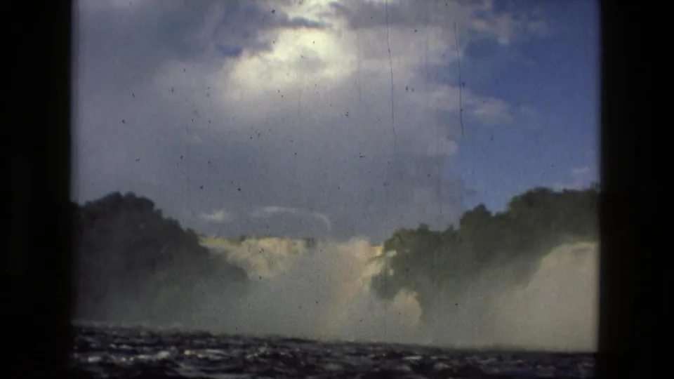 1979 8mm footage near Manaus, Brazil, showing a low, handheld view of river rapids, waterfall spray, and dense green shoreline.