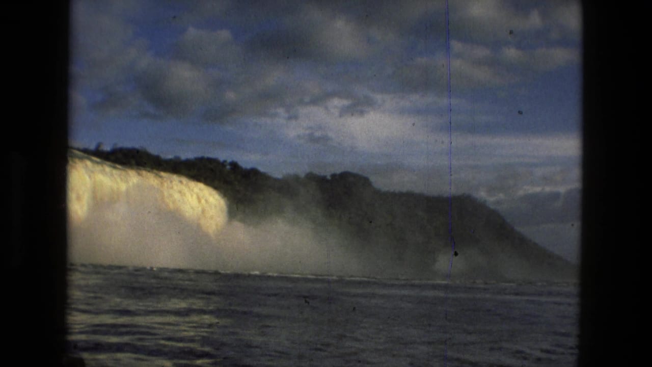 1979 8mm view near Manaus, Brazil, showing a wide waterfall, mist, river water, cloudy sky, and dark film-frame borders.