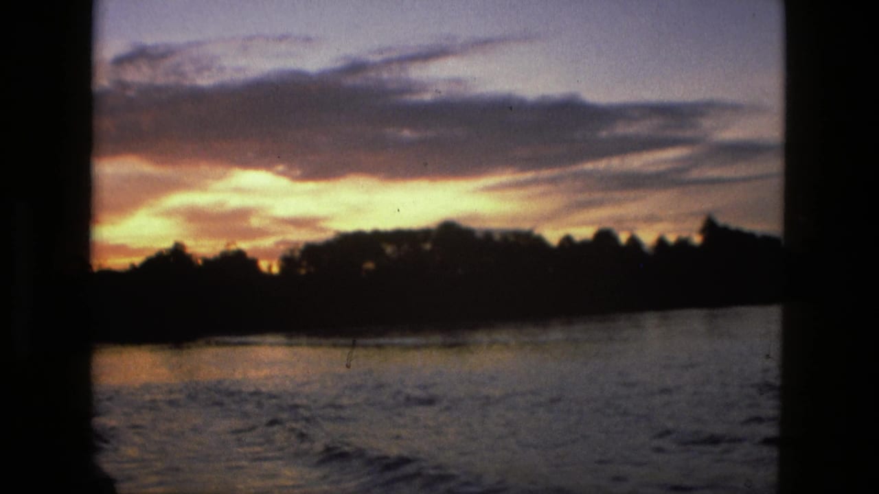 1979 8mm Manaus footage showing sunset color above water and a silhouetted forest edge.