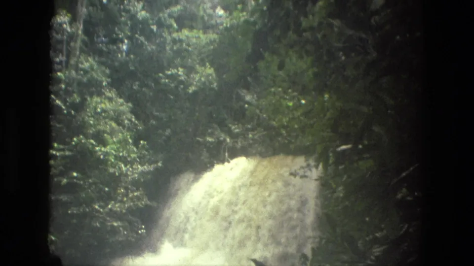 1979 8mm footage near Manaus, Brazil, with a large jungle waterfall lit by sun and surrounded by thick vegetation.