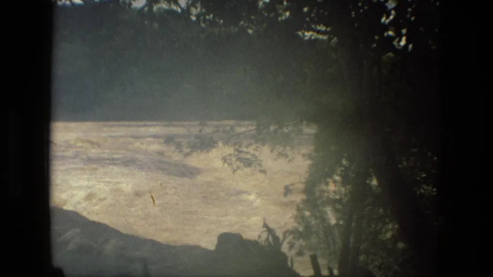 1979 Manaus, Brazil 8mm view of turbulent river water through a darker wooded foreground.