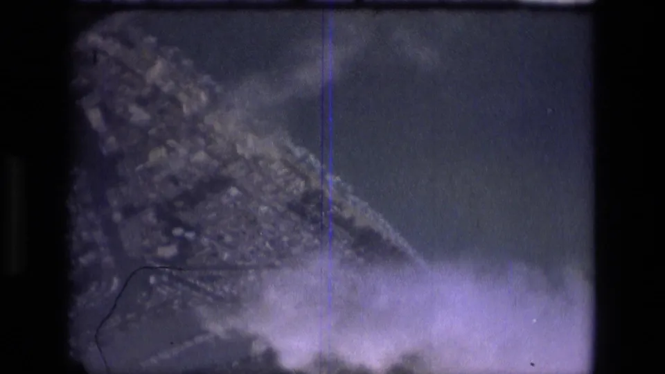 Final 8mm frame with heavy blur, purple cast, scratches, and indistinct outdoor shapes from the Manaus travel clip.