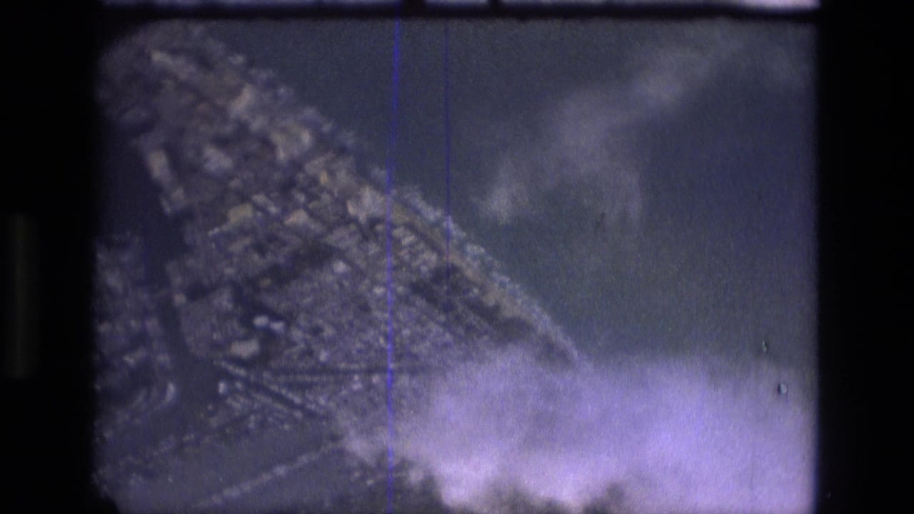 1979 8mm aerial view over Manaus, Brazil, showing dense urban blocks near water through haze and film grain.