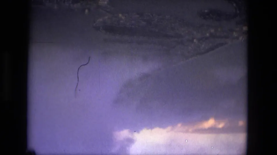 1979 8mm aerial view near Manaus, Brazil, showing purple-blue cloud cover and indistinct land or water below.