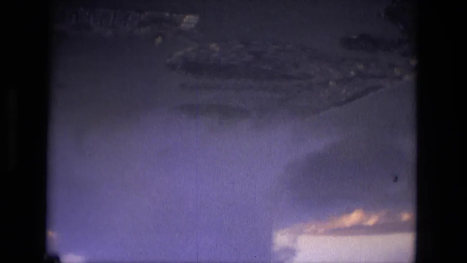 1979 8mm travel footage near Manaus with cloud layers and faint terrain or river forms seen from above.