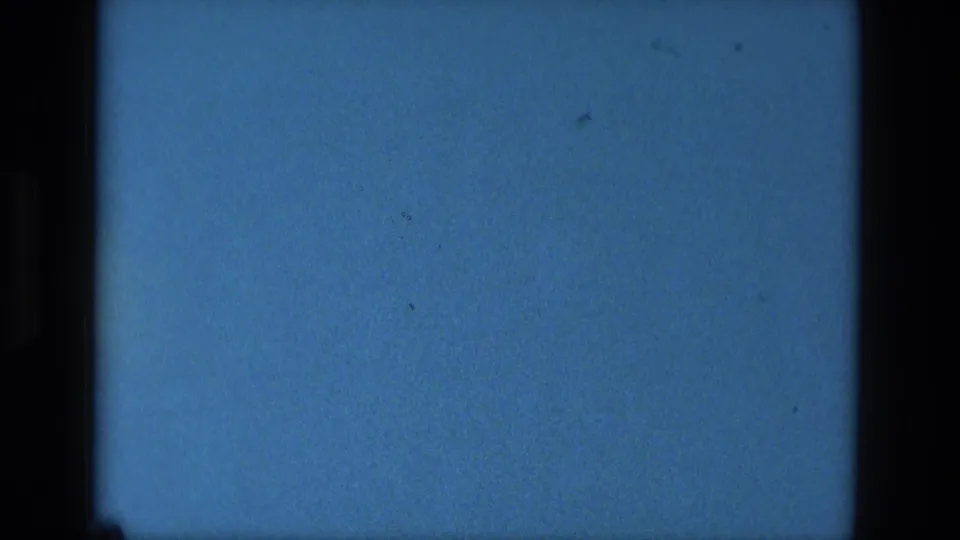 Lower reel-end frame from the 1979 Manaus 8mm clip, showing a horizontal film line, blue tint, dust, and black borders.