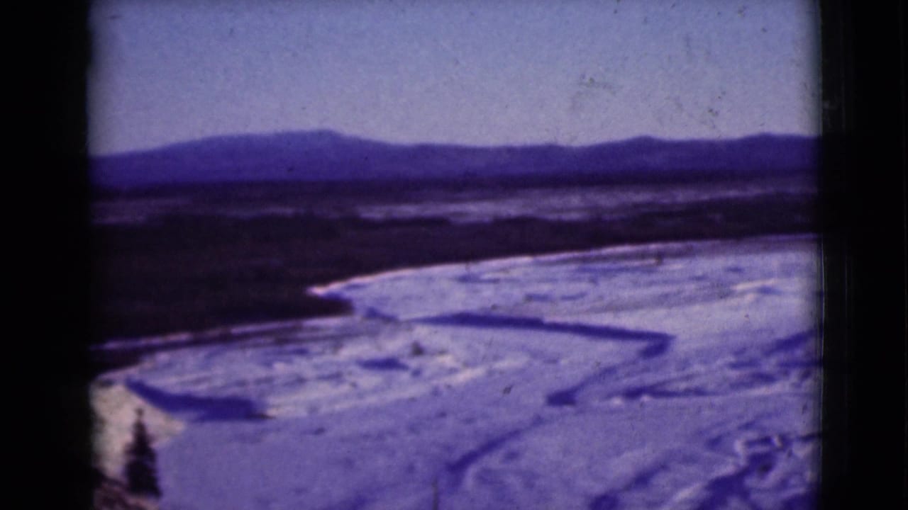 Frozen river valley with distant mountains and snow in an 8mm frame.