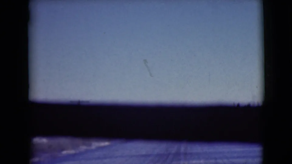 1946 Alaska road-travel frame with a pale sky, dark land band, and faint roadway texture inside visible 8mm borders.