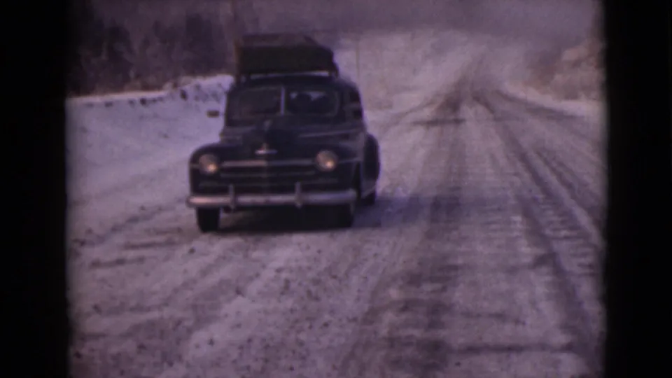 Near the end of the clip, the loaded sedan approaches on the snow-covered Alaska road in soft, grainy 8mm footage.