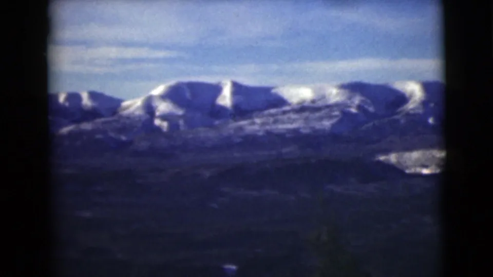 1946 Alaska 8mm frame showing a broad snowy ridge, shadowed valley floor, and visible film-frame separation.