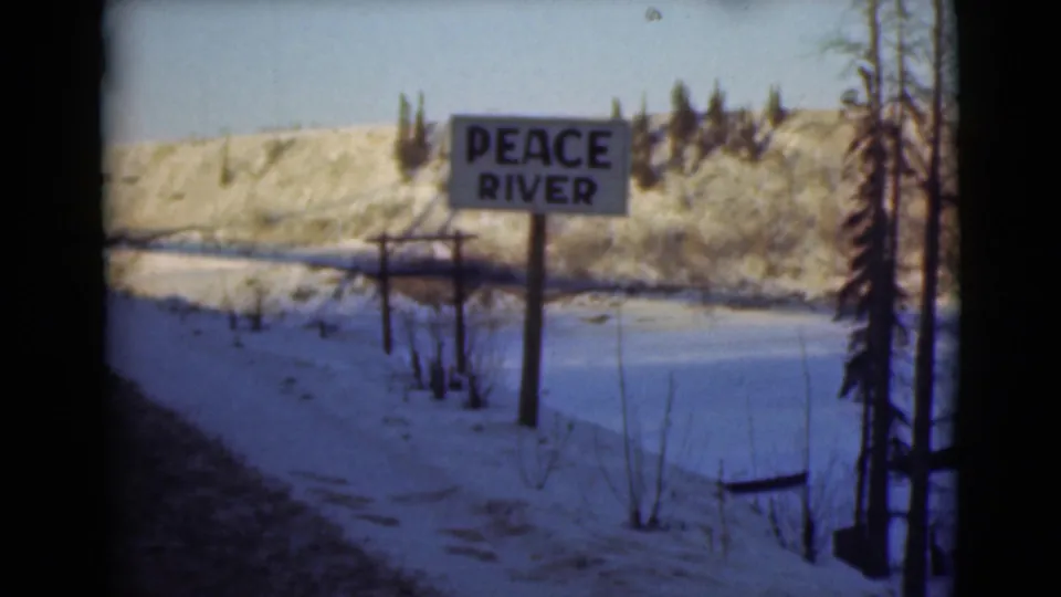 The Peace River sign remains centered in a snowy 1946 Alaska travel view, with bare trees and a low winter hillside behind it.