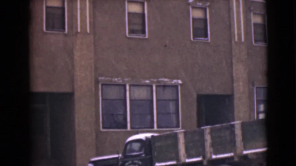 1946 Alaska 8mm frame with a vintage truck parked in front of the Dawson Hotel facade during snowy conditions.
