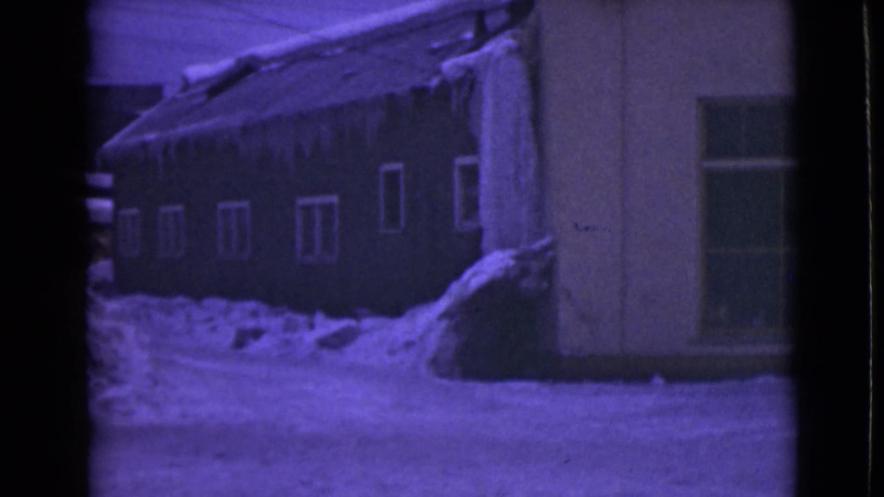 Snow-covered house exterior with icicles hanging from the roofline.