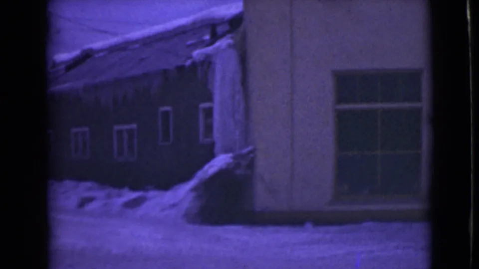 1946 Alaska 8mm frame of a house corner and window surrounded by deep snow and icicles.