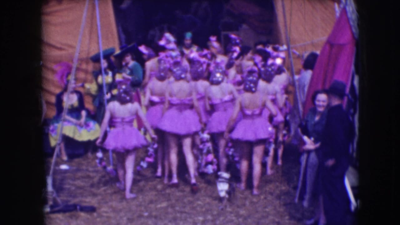 1948 Sarasota circus footage shows dancers in pink tutus and sequined headpieces moving together near canvas tents and onlookers.