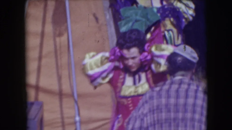 1948 Sarasota backstage circus view with a red-costumed performer partly obscured by a passerby near tent poles and canvas.