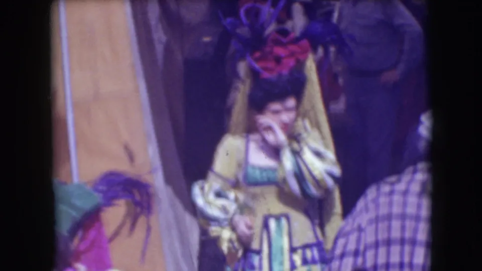 Backstage 1948 Ringling Brothers Sarasota frame with a female performer in yellow costume near canvas, feathered pieces, and nearby staff or visitors.