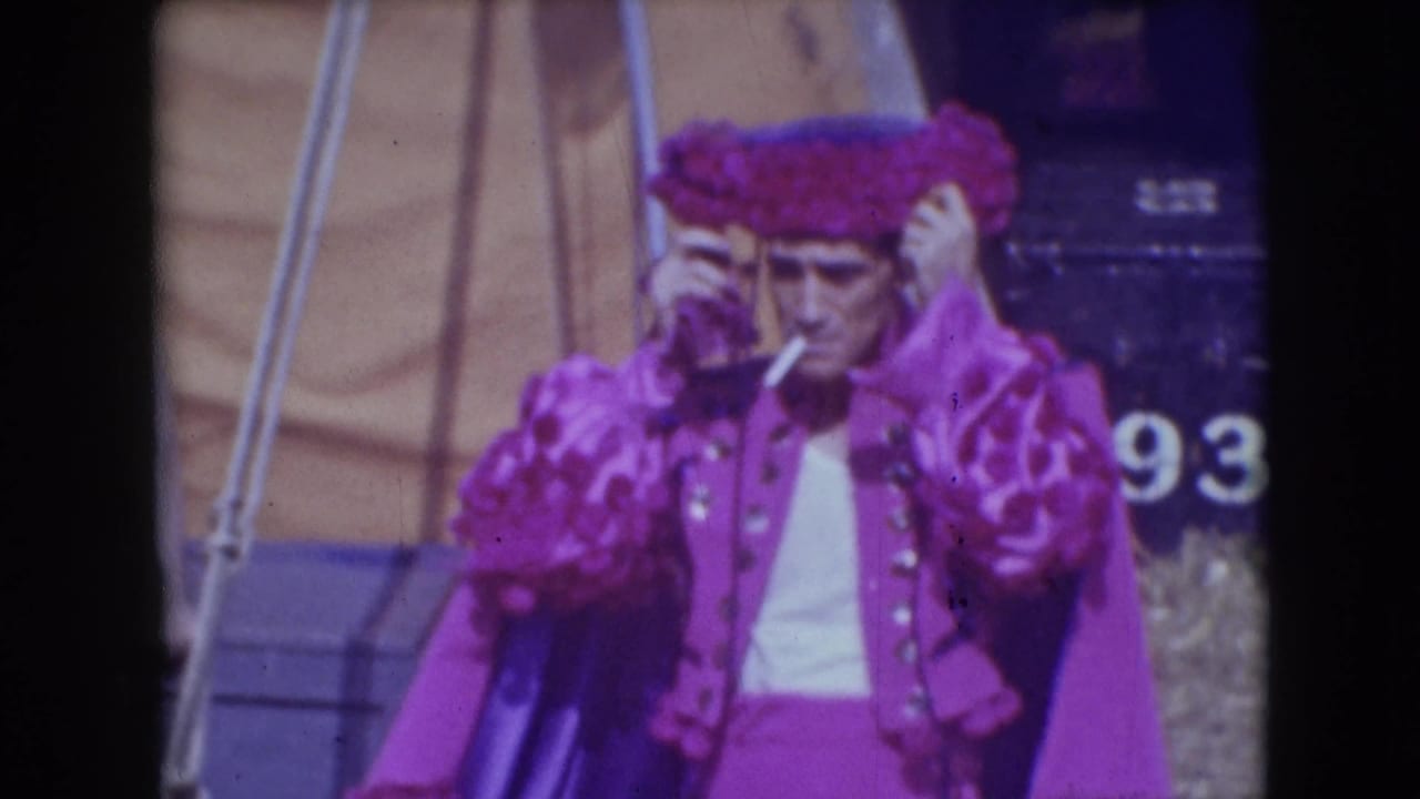 Circus performer in purple costume smoking while holding a feathered hat.
